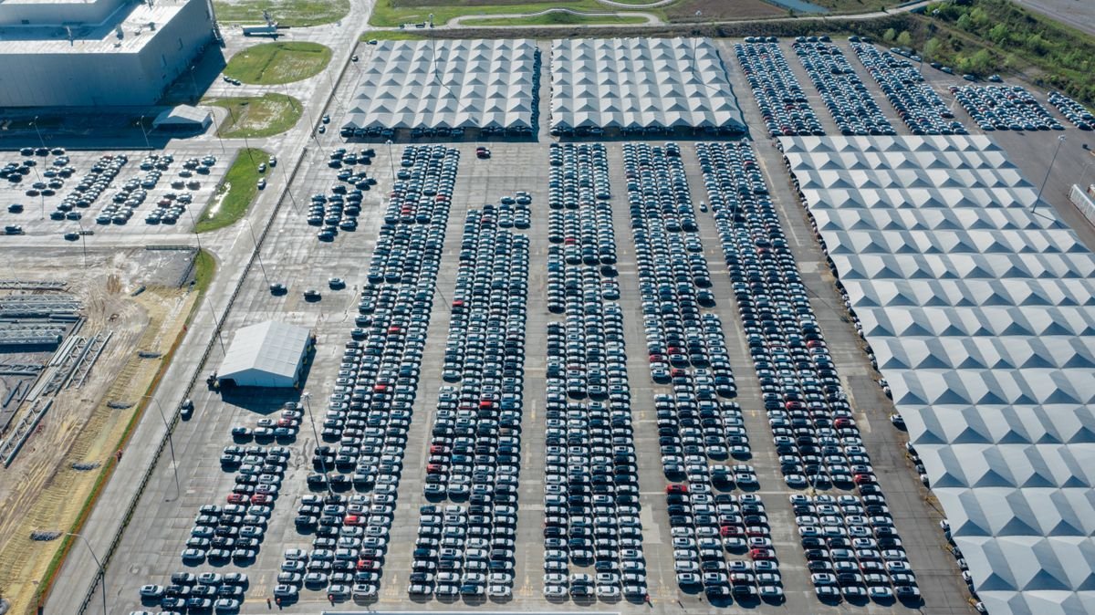 Vast paved vehicle storage facility with hundreds of parked vehicles