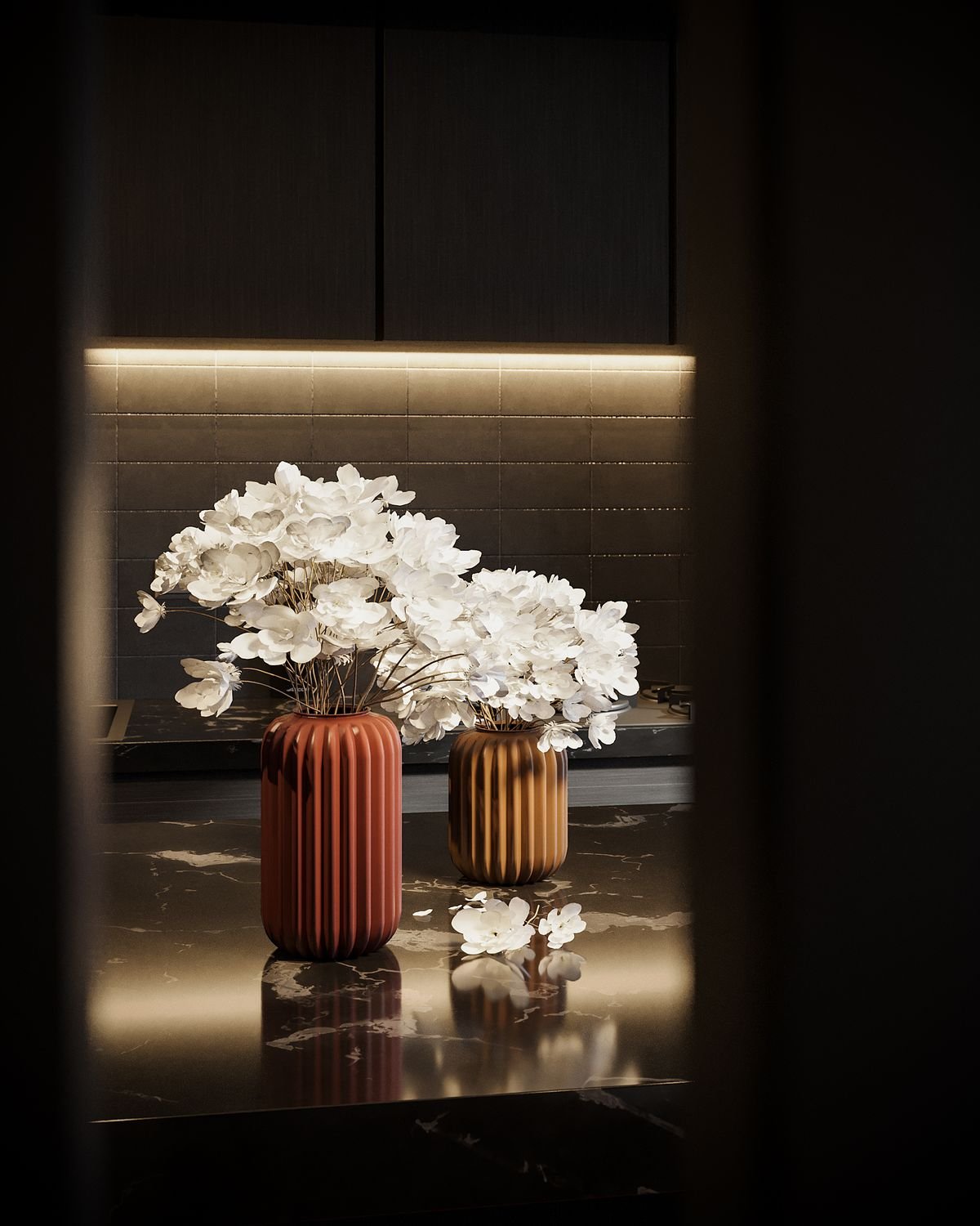 Dark console with white flowers in sculptural vases under warm accent lighting
