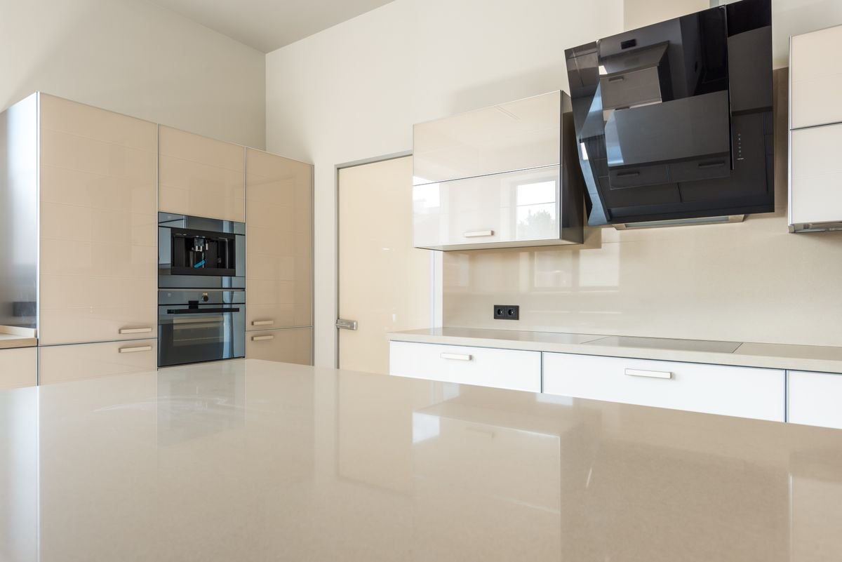Cream kitchen with built-in oven, extractor, and a polished island