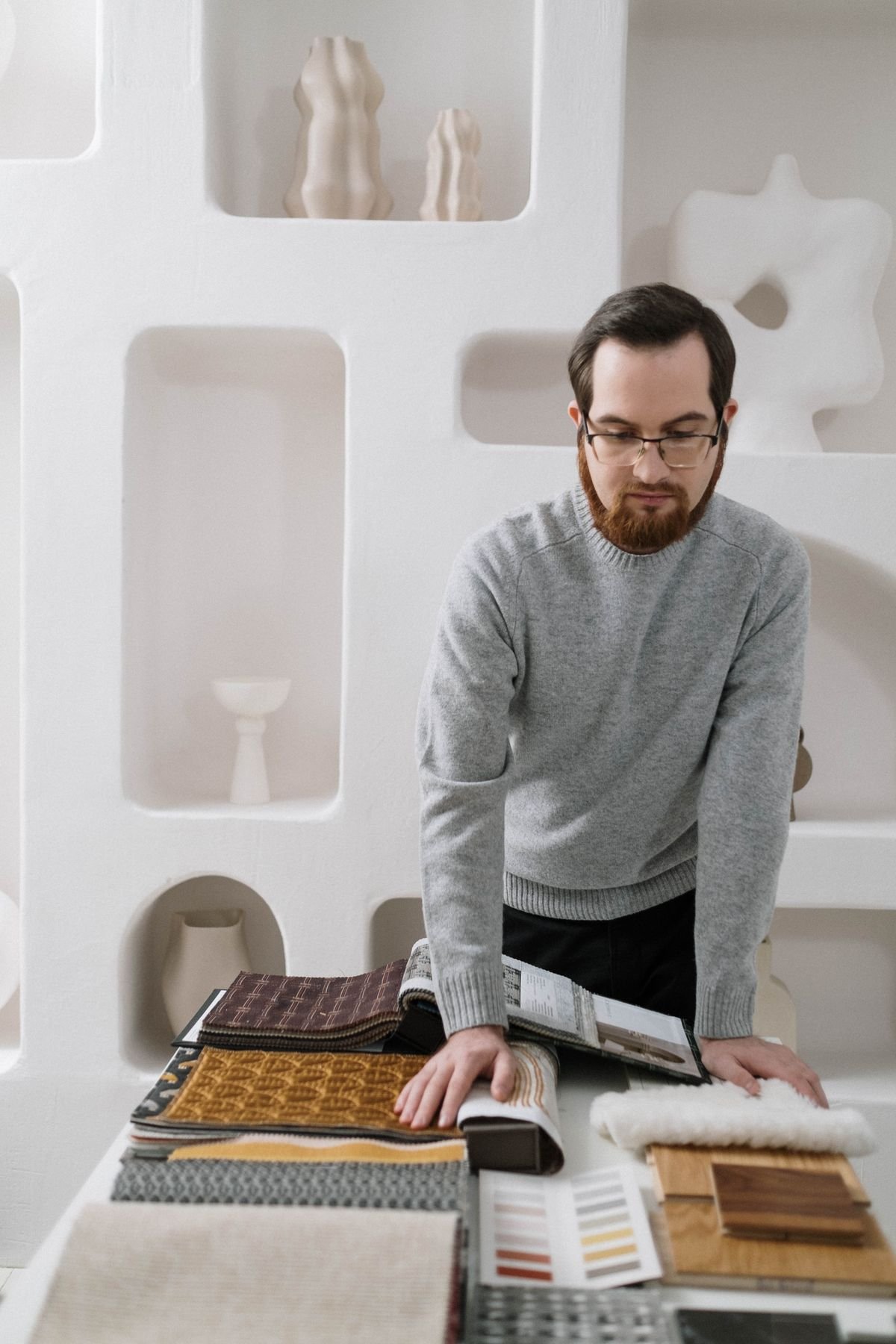 Designer reviewing fabric and material samples in a studio