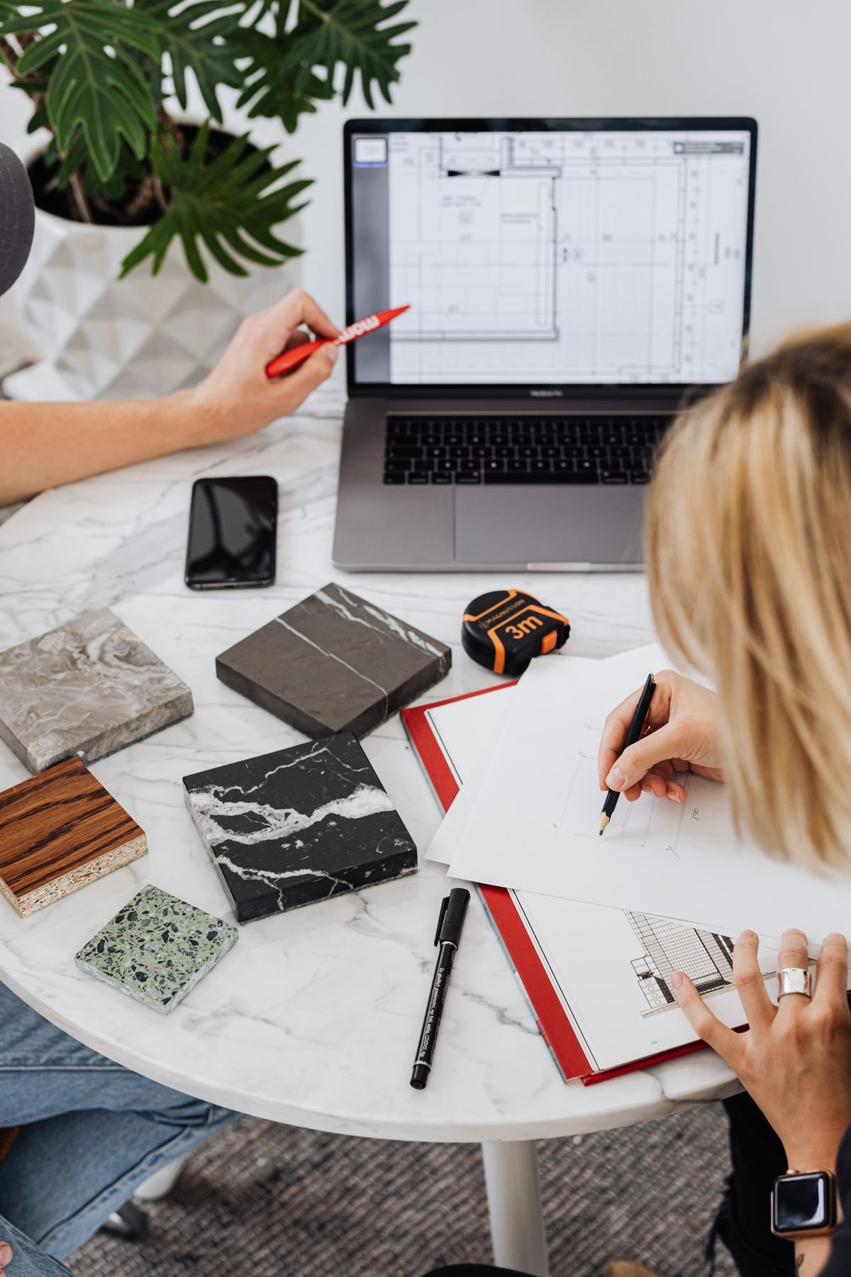 Designers planning interior spaces with laptop and material samples