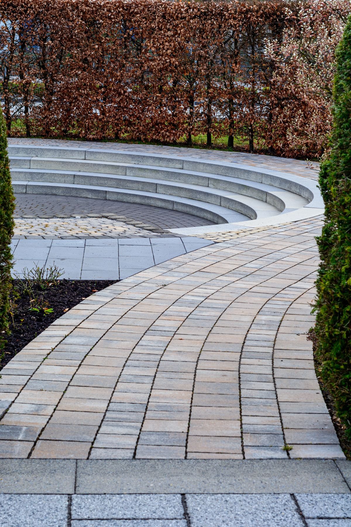 Curved paver pathway leading to a seating area