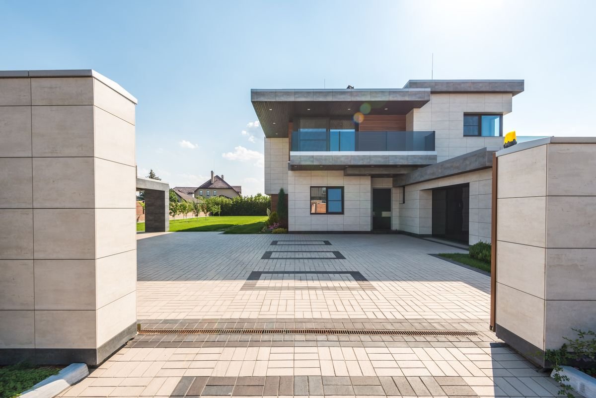 Modern house with a herringbone-pattern interlock paver driveway and geometric border