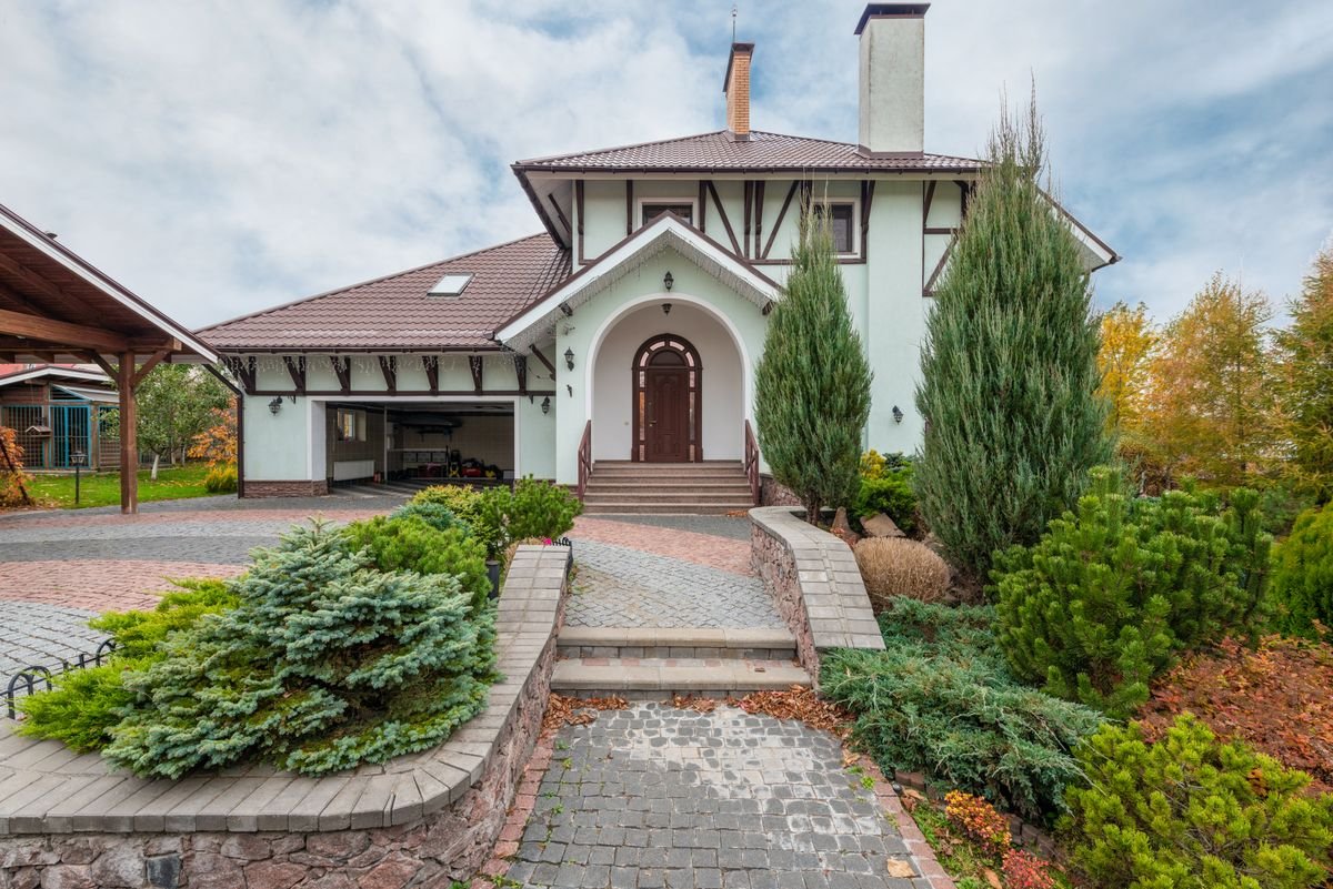 Traditional house with a stone paved pathway through landscaped garden