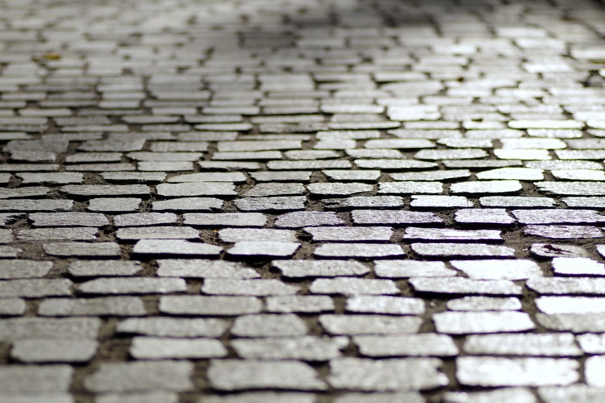 Light-coloured cobblestone setts laid in a tight, level pattern