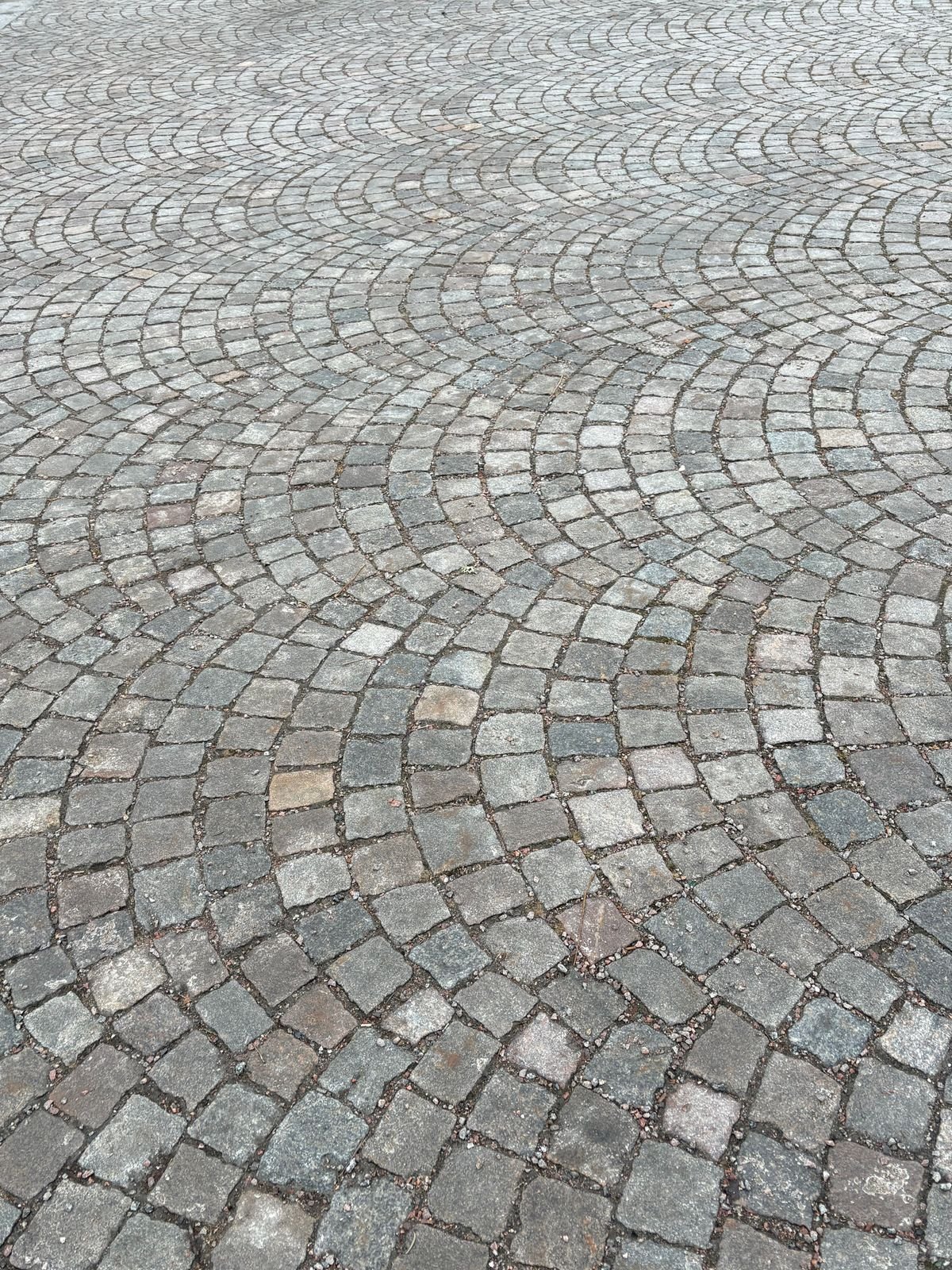 Fan-pattern cobblestone paving in a plaza area