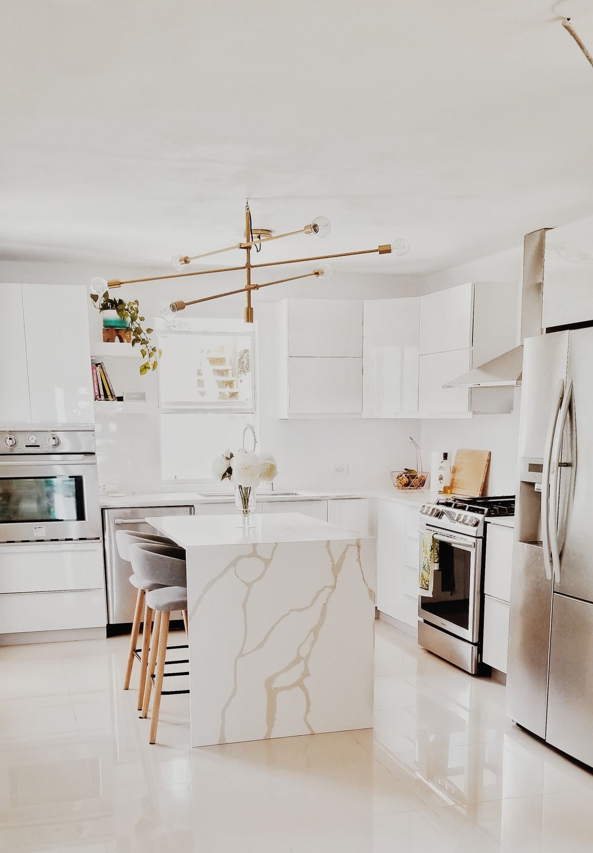 Bright modern kitchen with white cabinetry and marble-style island