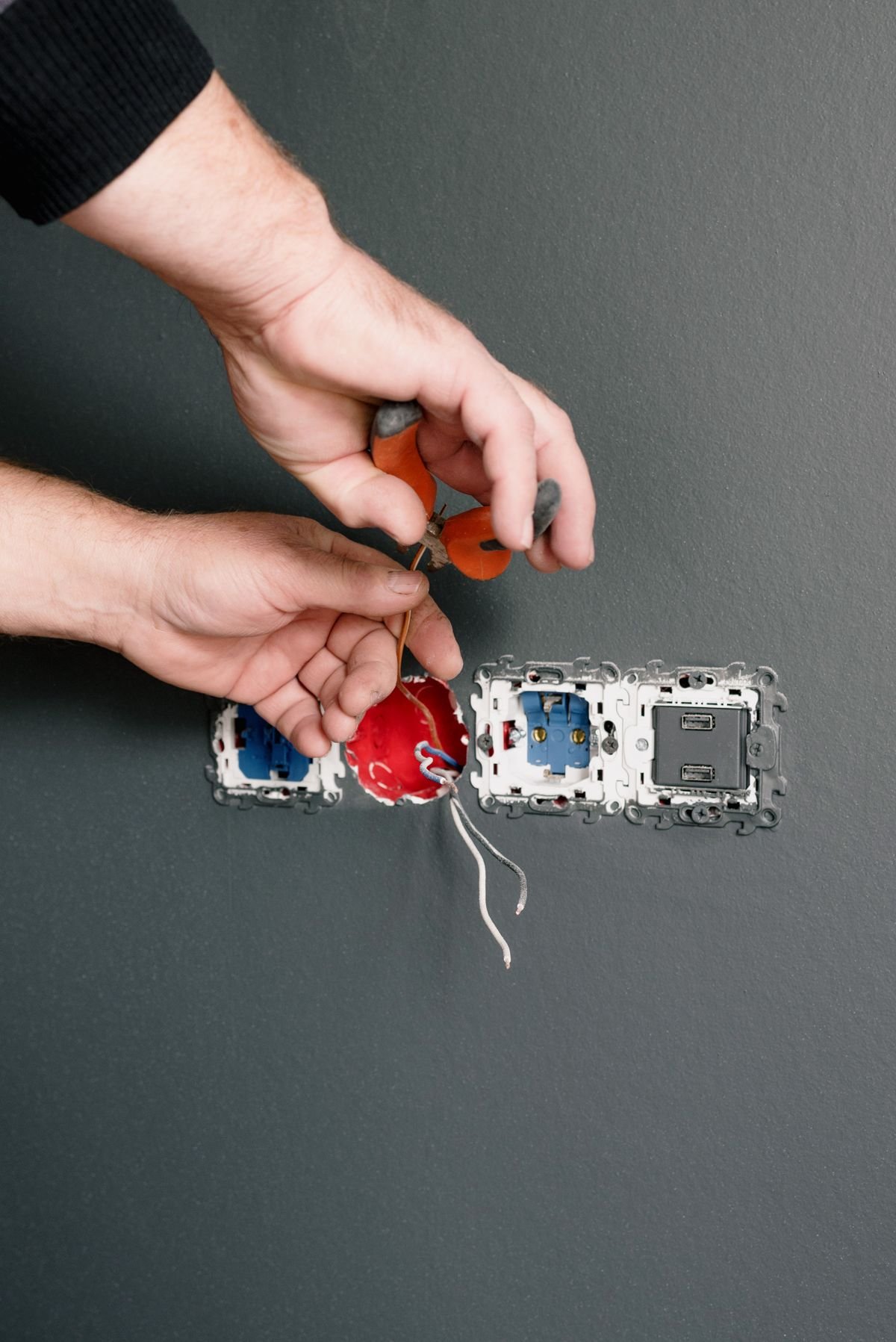 Electrician connecting wires to install wall sockets and switches