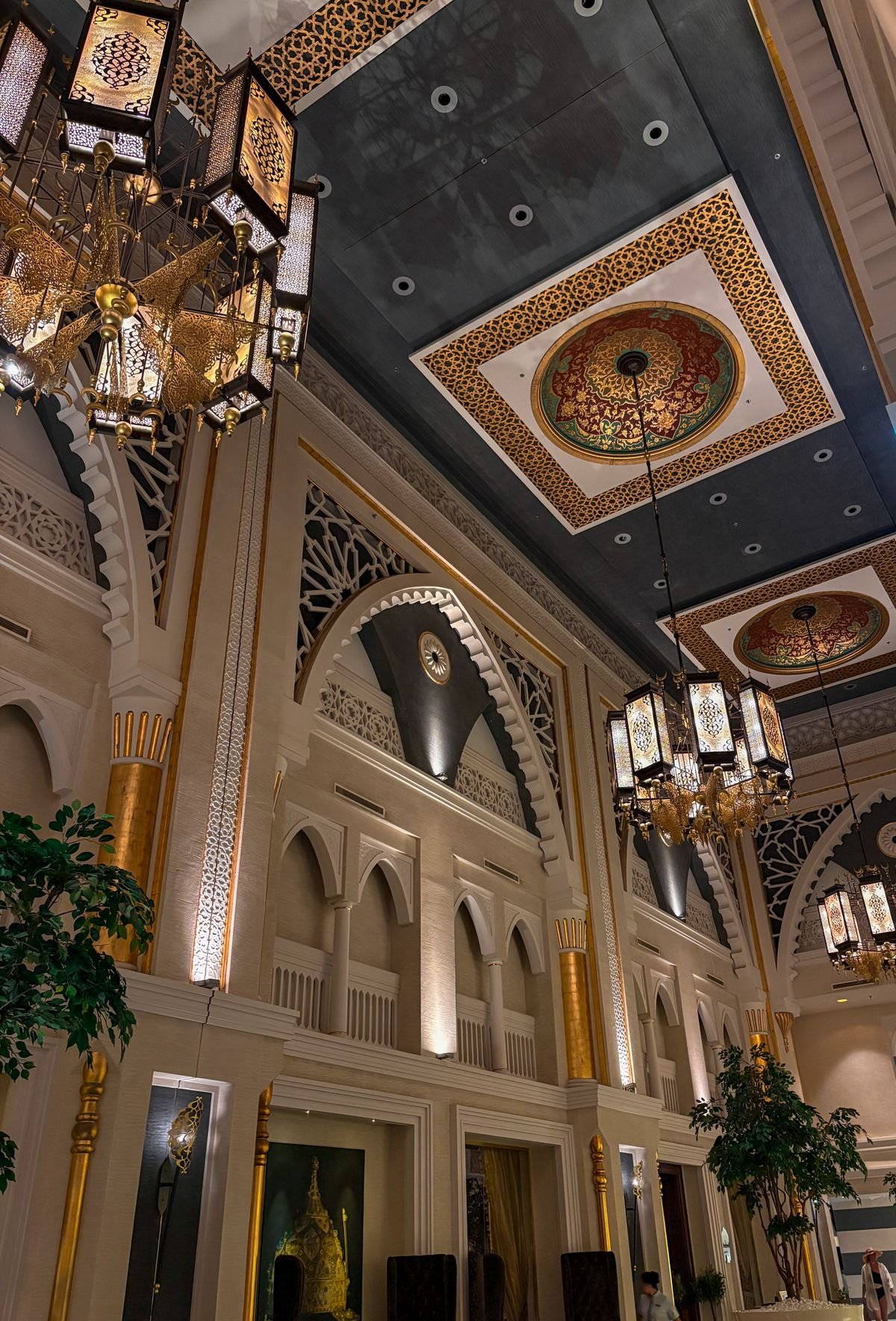 Ornate coffered ceiling with chandeliers in a grand hotel-style interior