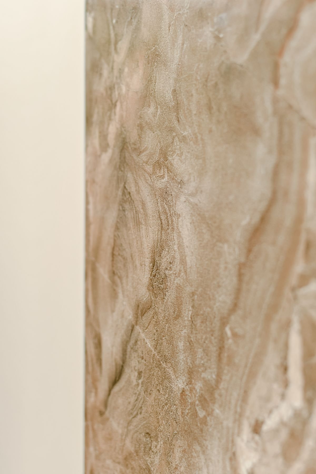 Edge of a honey-toned marble slab panel ready for fixing