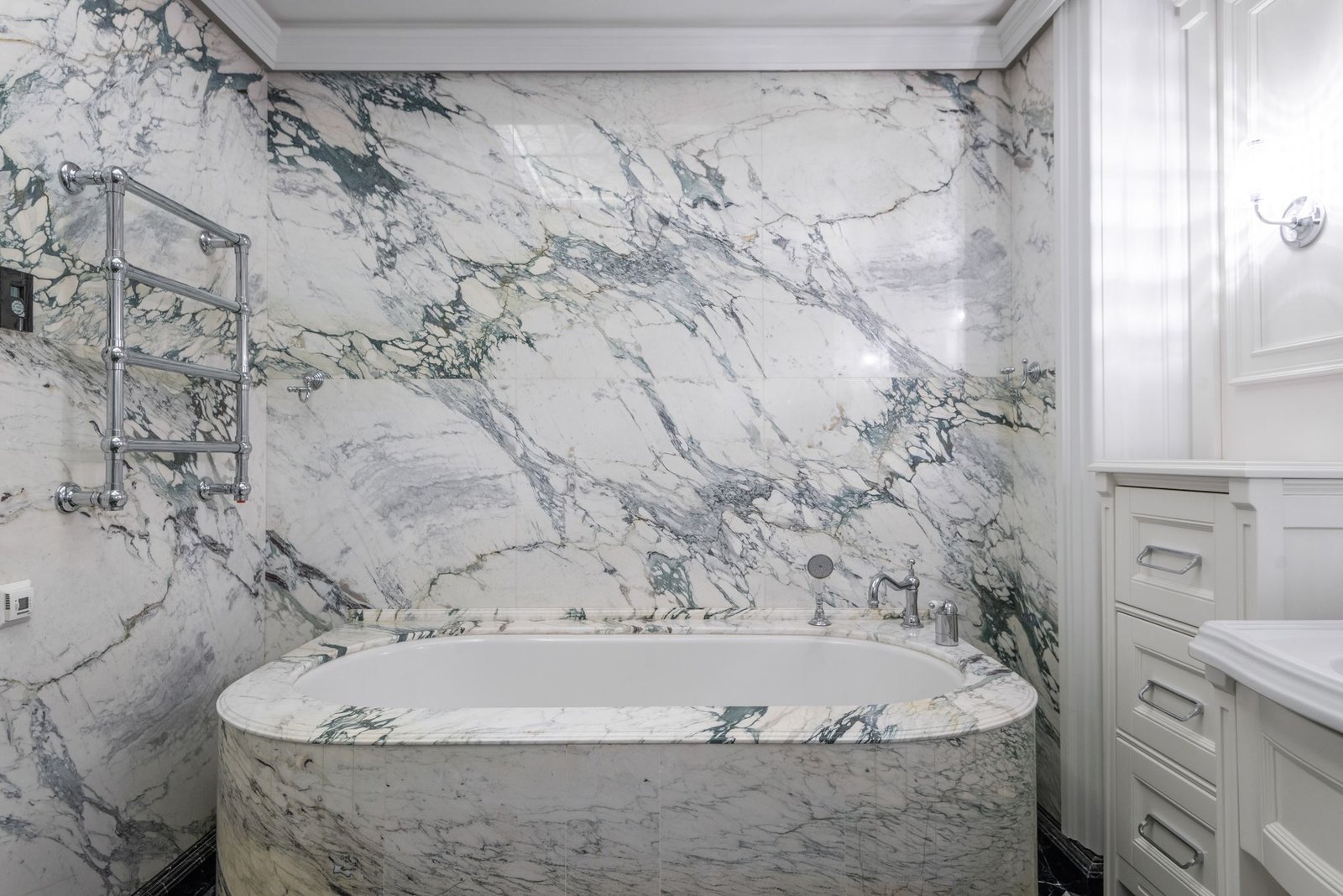 Luxurious marble bathroom with a full marble-clad bathtub surround