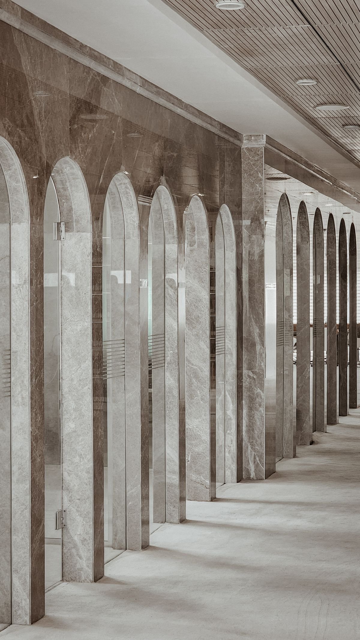 Polished marble corridor with glass arches reflecting soft light