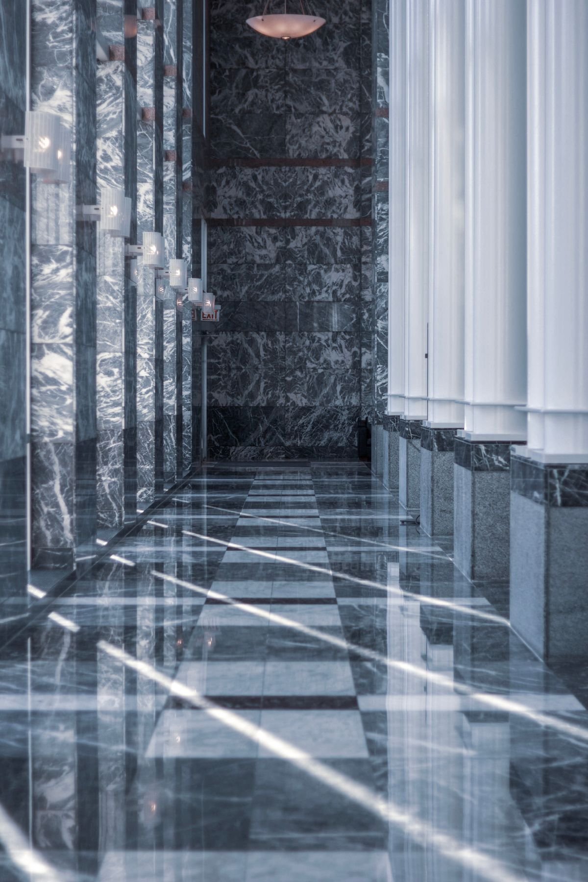 Polished marble hallway with tall columns and reflective flooring