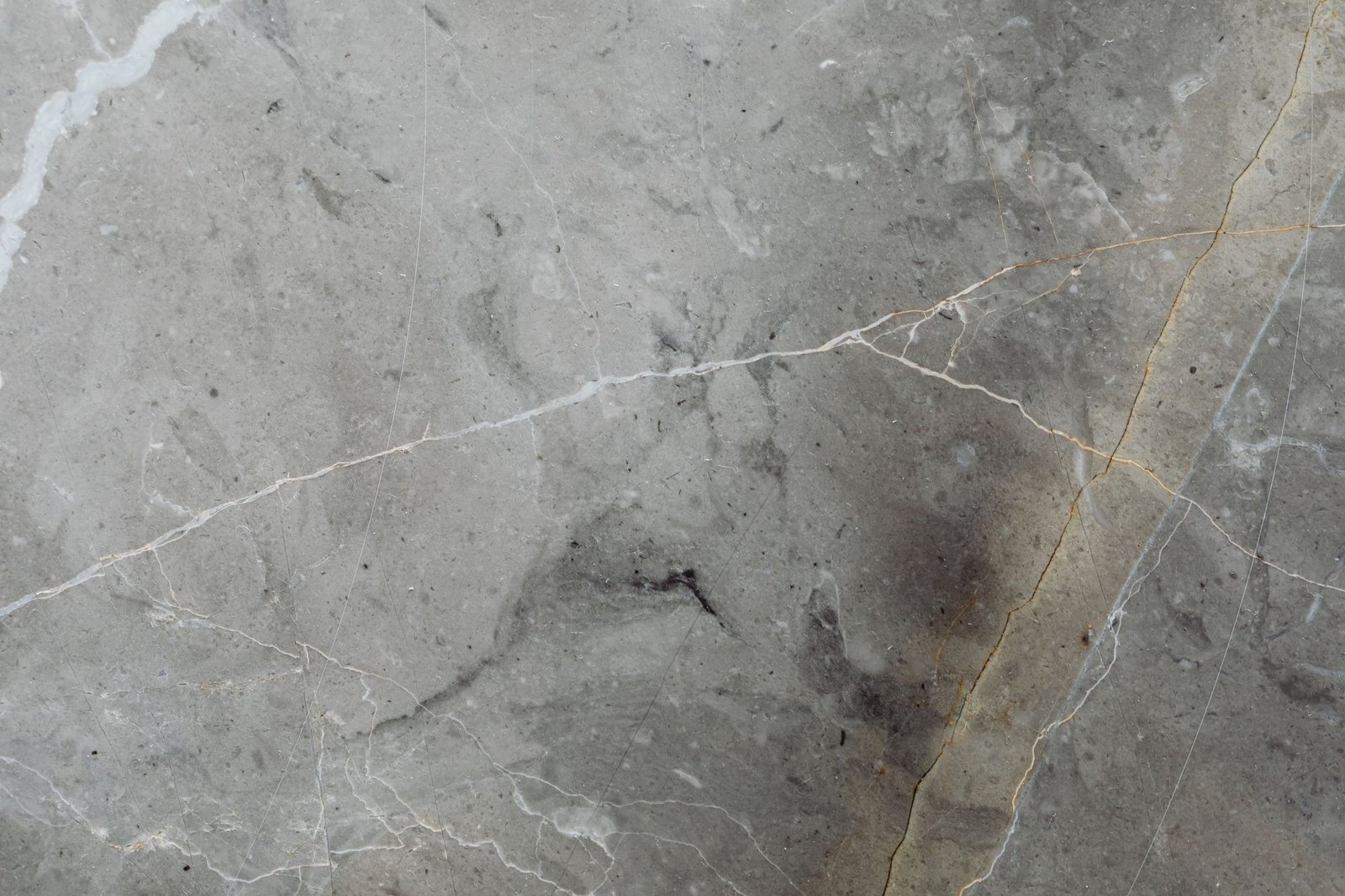 Weathered grey marble surface with a prominent crack and natural staining