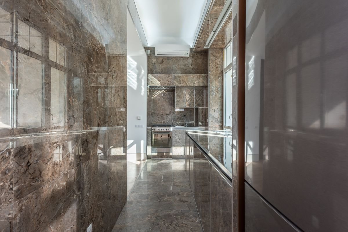 Elegant kitchen with new dark marble flooring and countertops
