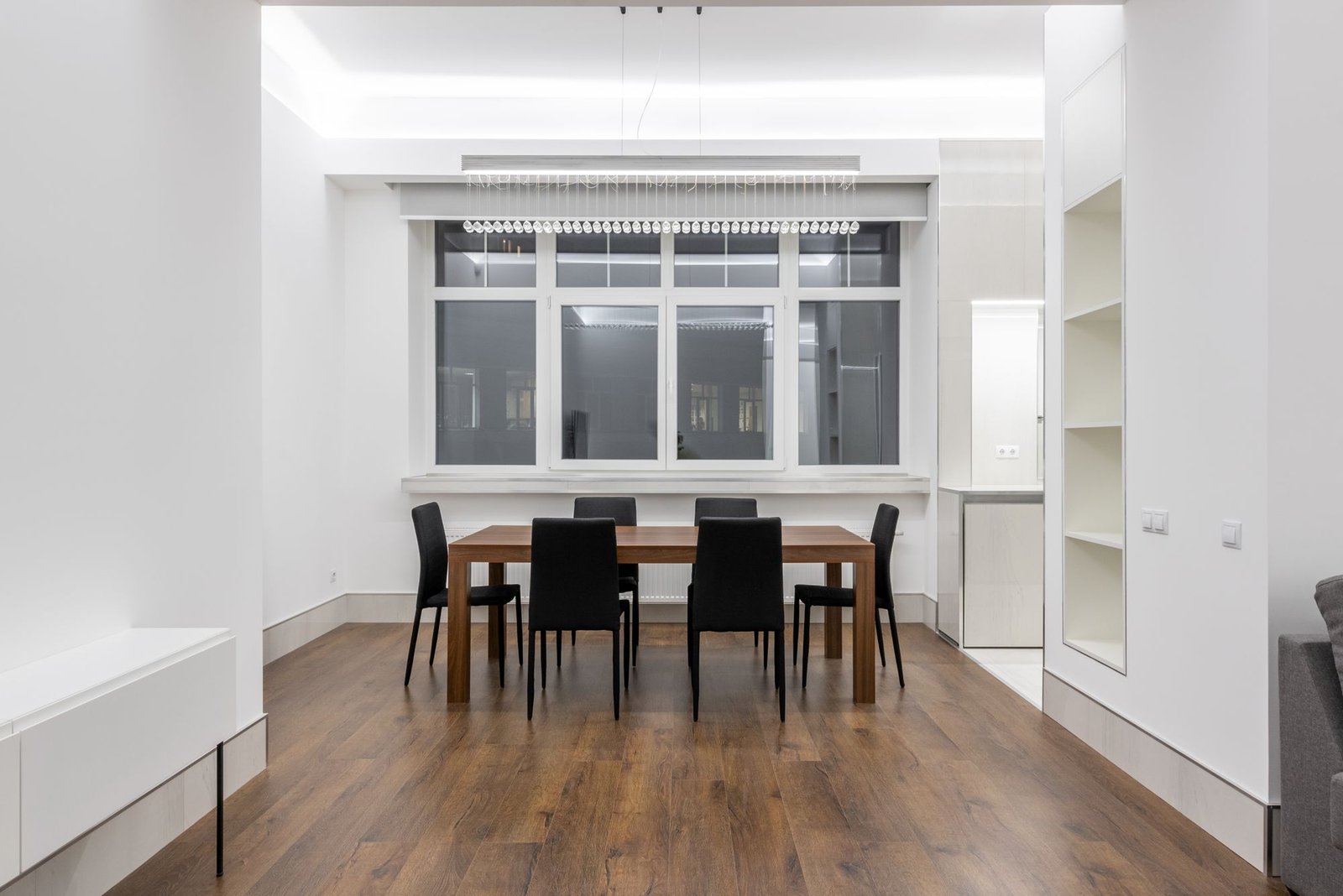 Meeting table in a white room with a cove-lit false ceiling and large windows