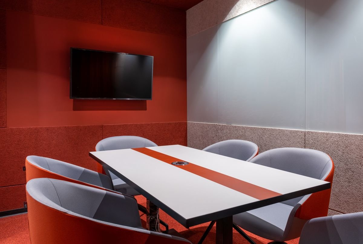Meeting room with red acoustic-style walls and a ceiling air-conditioning unit