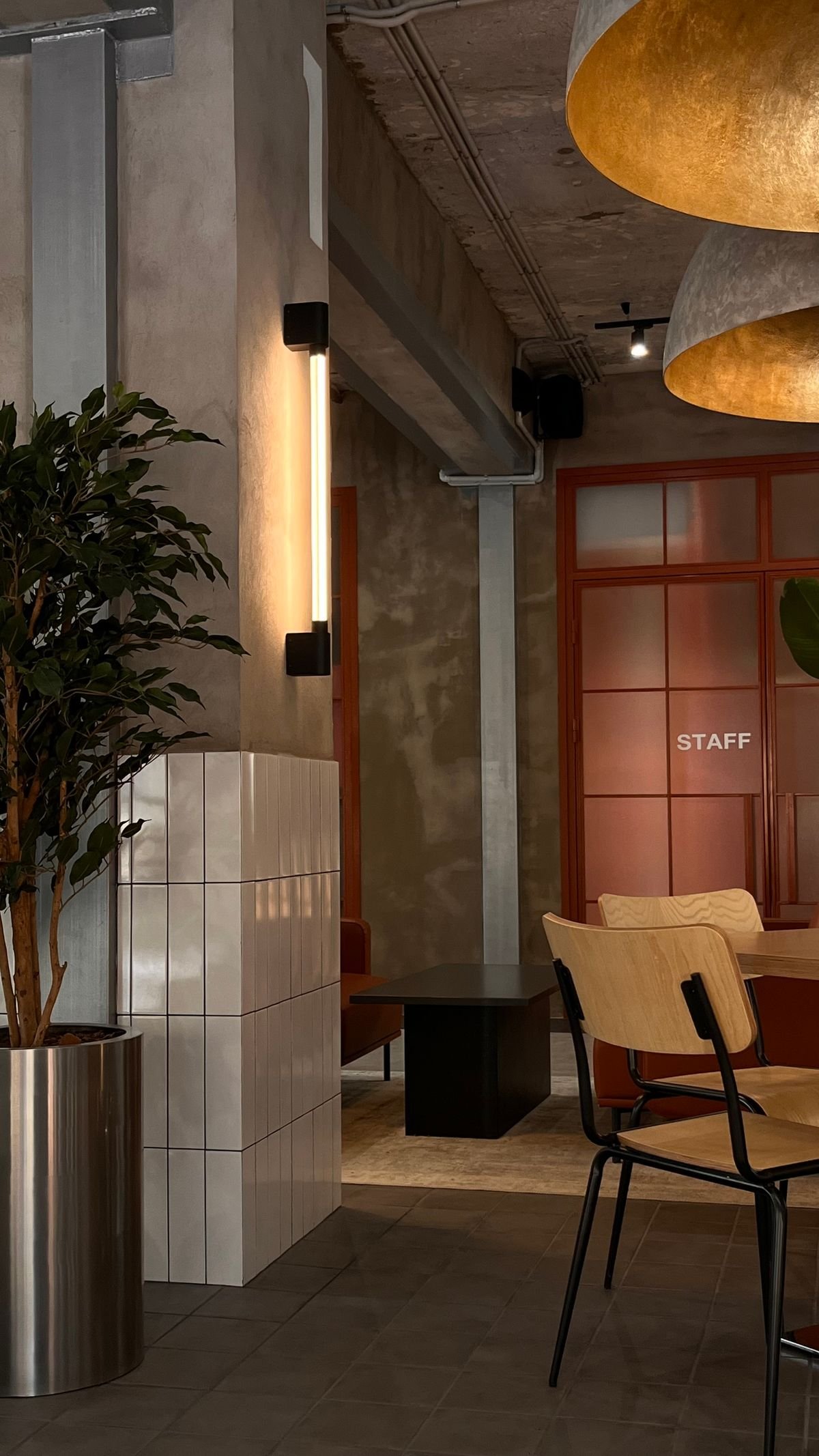 Modern office lobby with large round pendant lights and an industrial ceiling