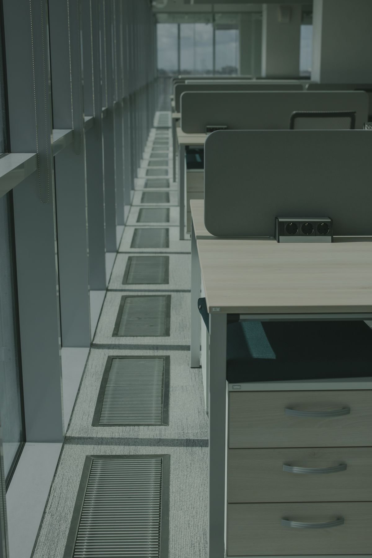 Sunlit office desks separated by low partitions