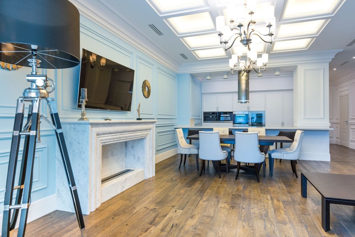 Dining room with a chandelier, marble fireplace, and a warm wooden floor