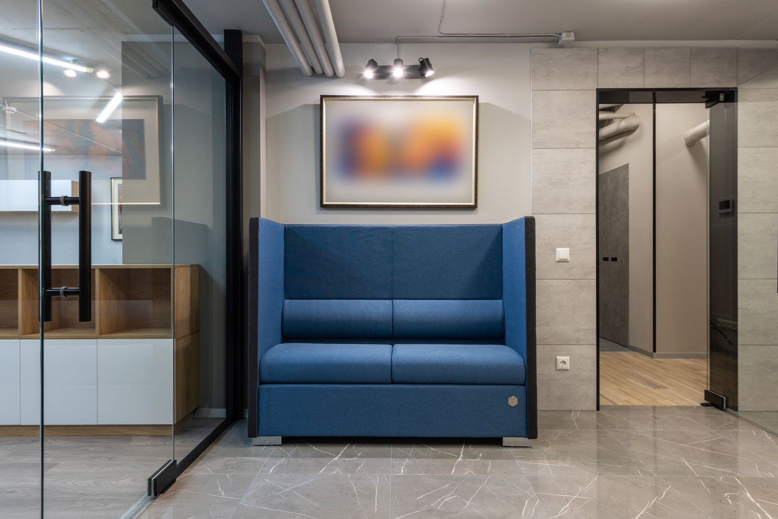 Spacious contemporary office hall with a comfortable sofa on a tiled floor