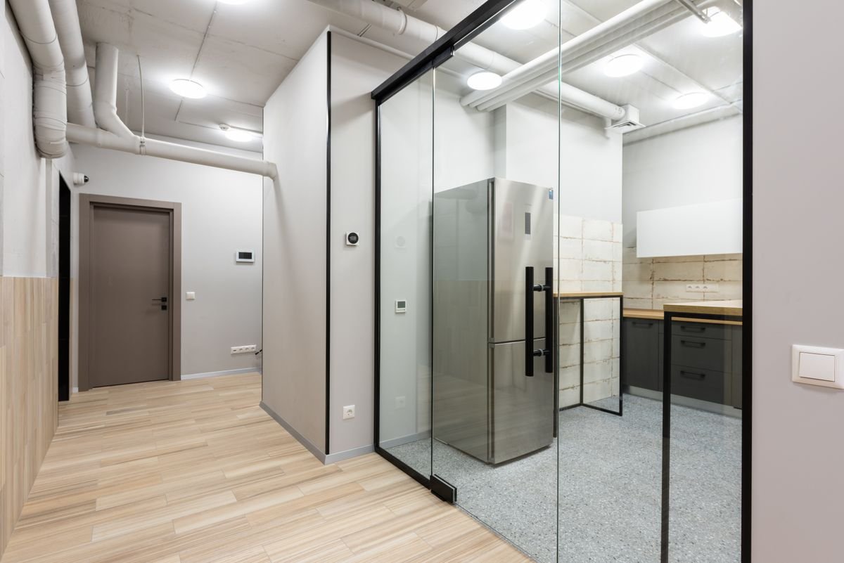Office hallway and kitchen area with counters and appliances in a contemporary workplace