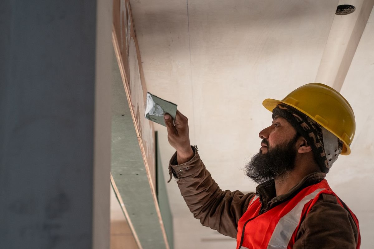 Construction worker applying plaster to a ceiling
