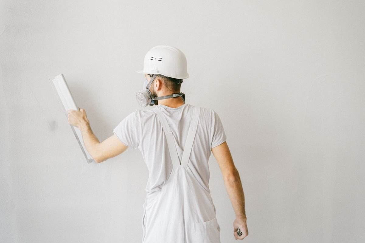 Construction worker in safety gear plastering