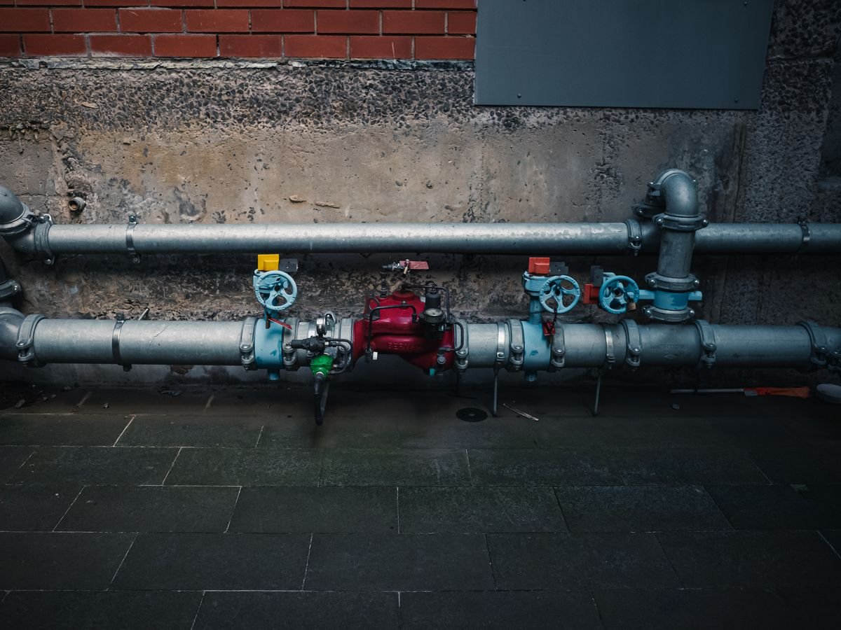 Water pipes and valves running along a wall