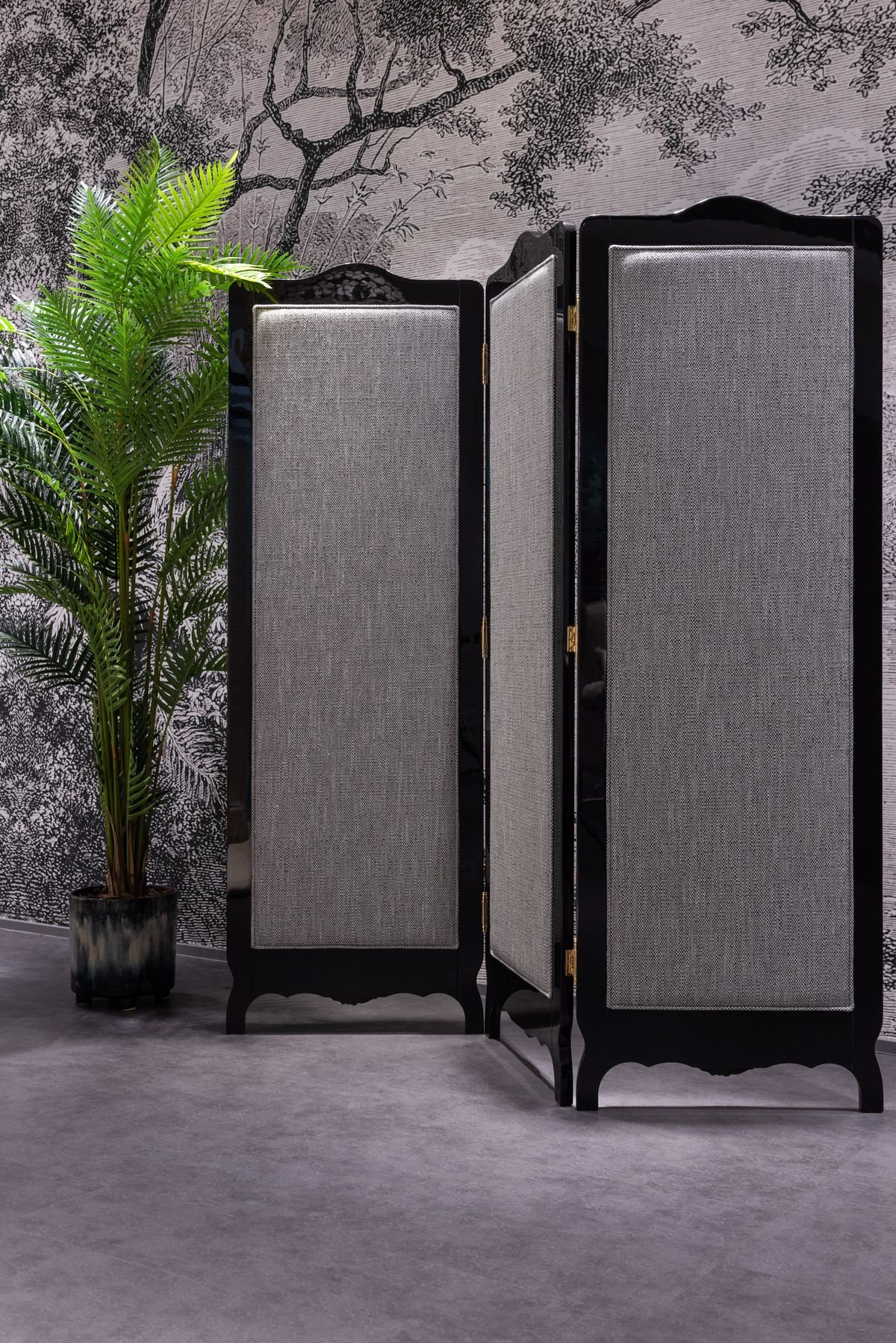 Slim room divider beside a potted plant in a light apartment