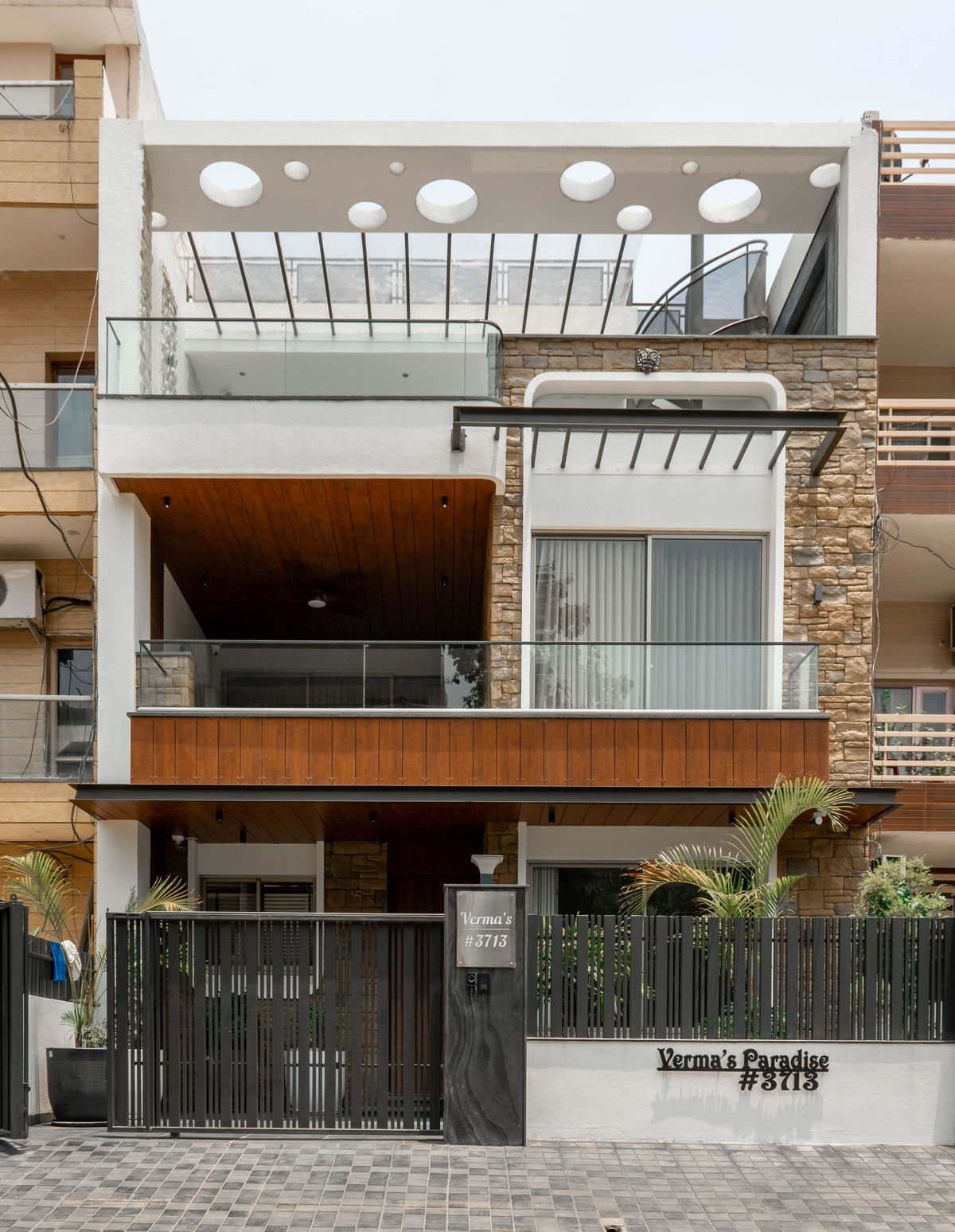 Contemporary urban home facade with circular cutouts and stone siding