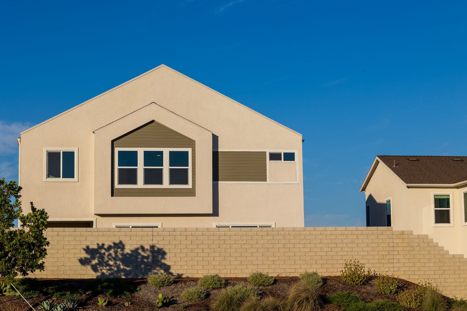 Modern stucco house with a smooth, even finish against a clear blue sky