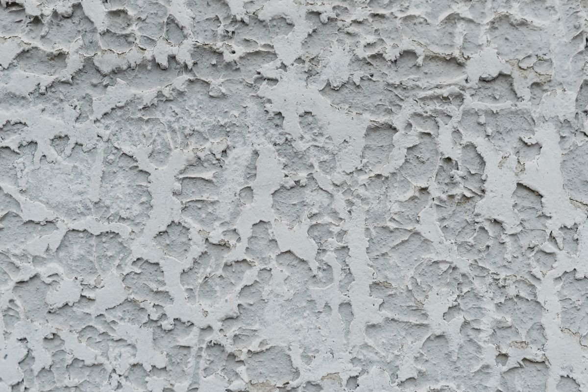 Close-up of rough textured gray stucco wall surface