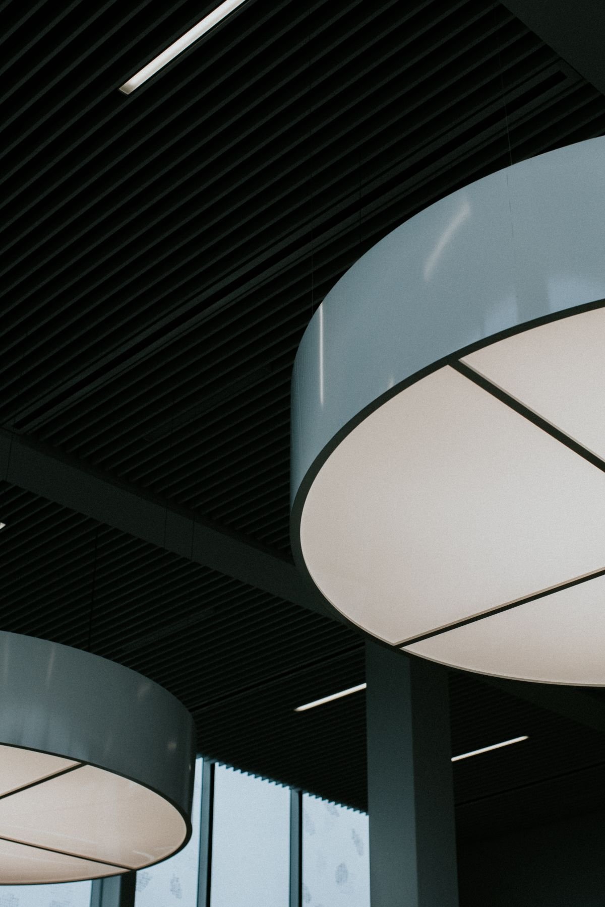 Dark suspended ceiling with large round lighting panels hanging below it