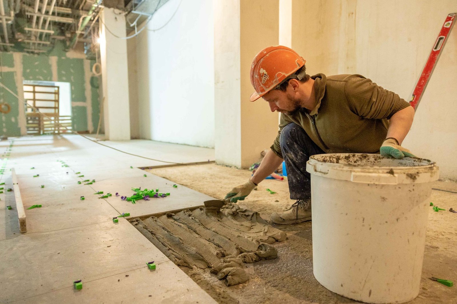 Construction worker installing floor tiles