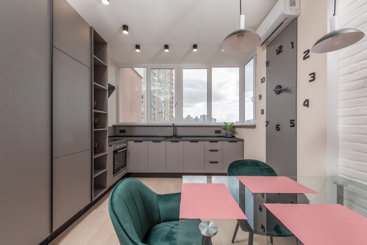 Kitchen and dining corner with grey units, a concrete ceiling, and spotlights