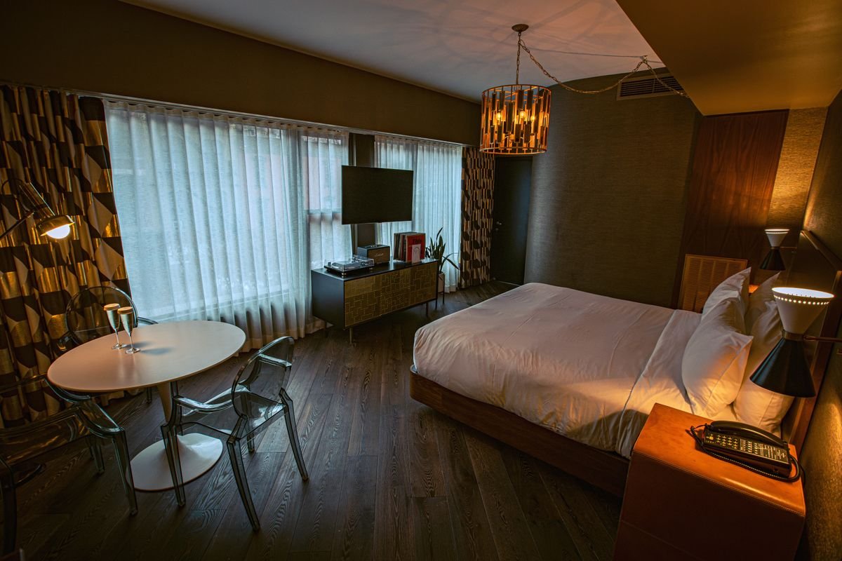 Boutique hotel room with a dark wood-look floor and warm lighting