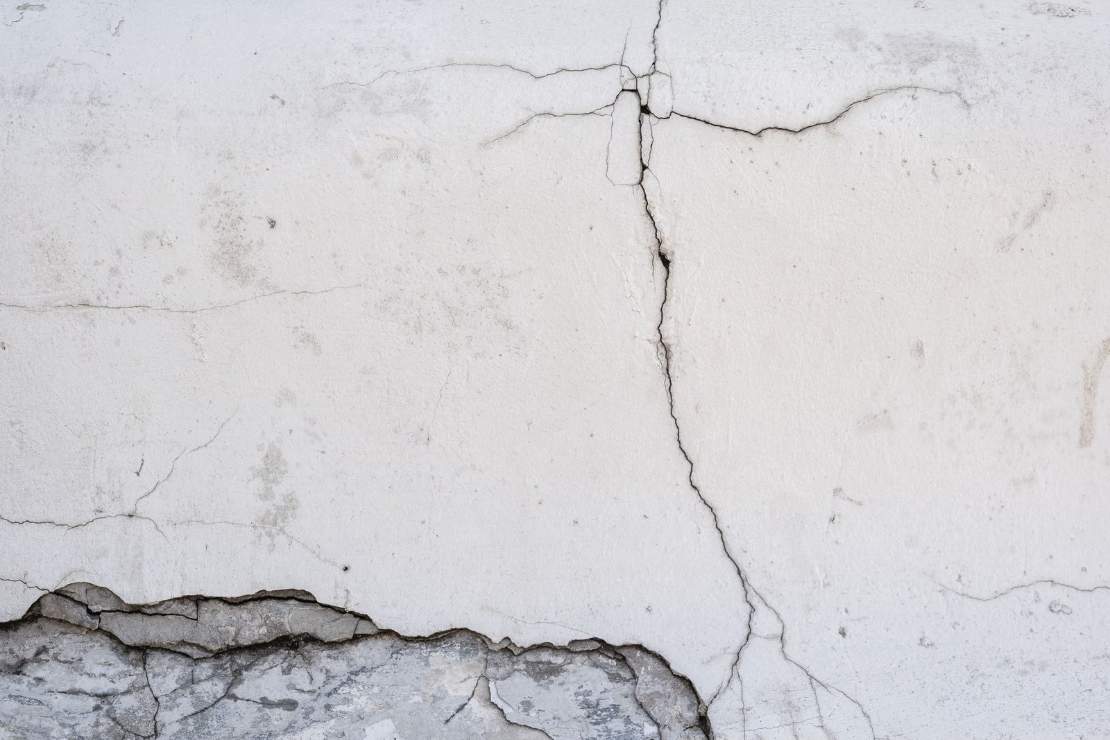 A long vertical crack running down a white painted wall