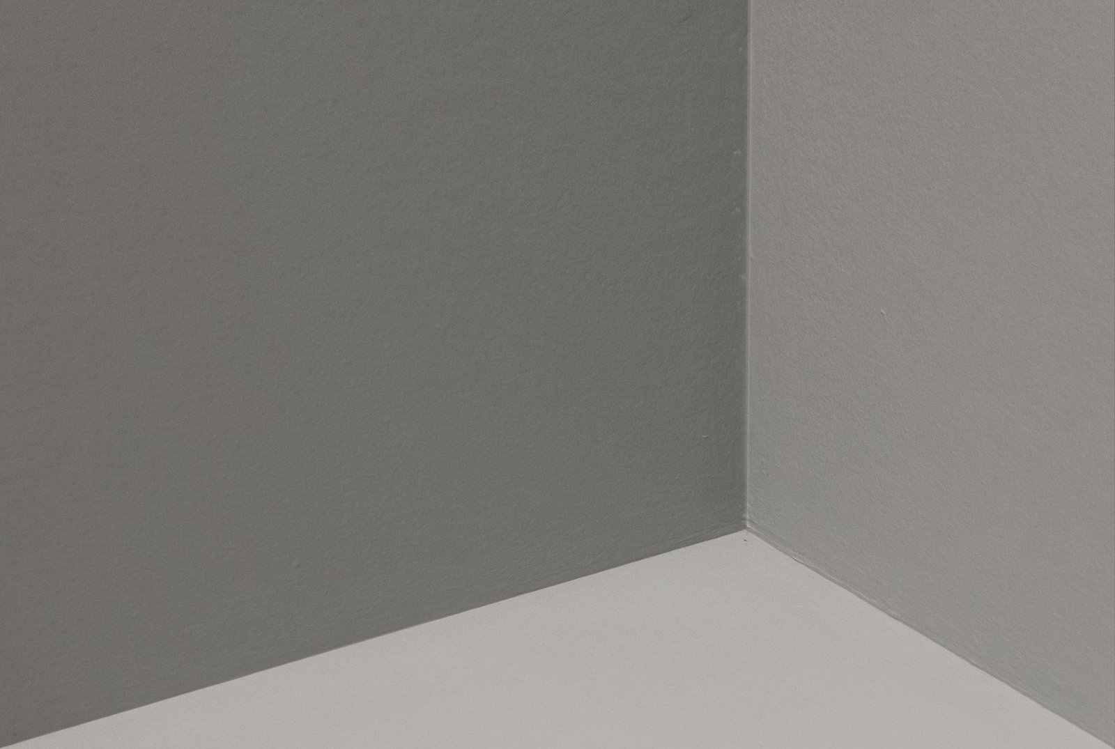 Smoothly painted grey wall corner in a minimalist interior room