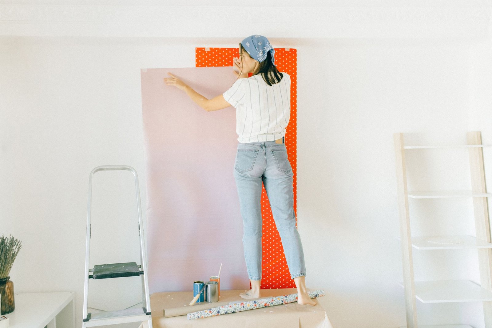 Woman applying wallpaper on a wall for home renovation