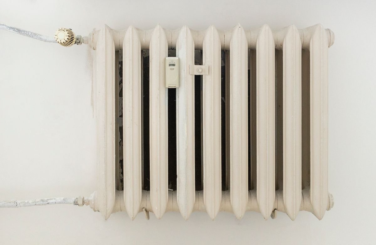 A wall-mounted heating unit in a bright renovated room