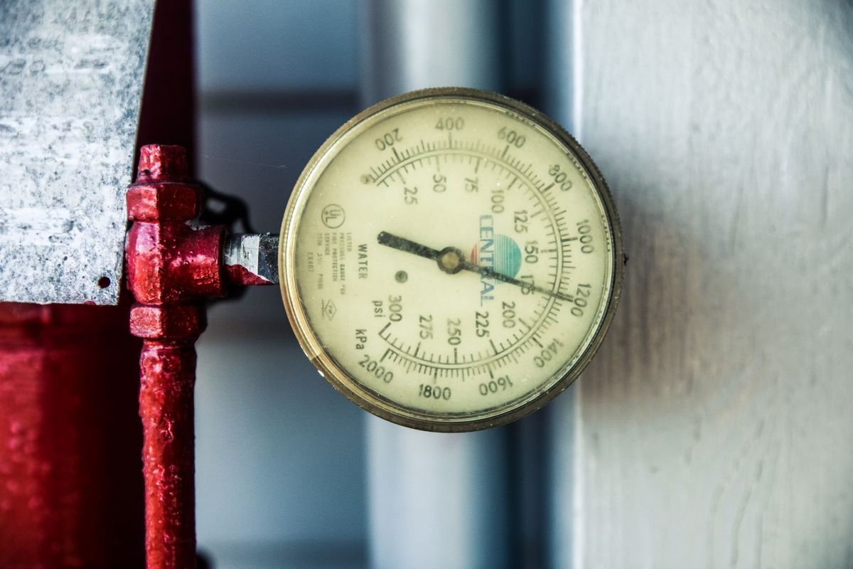 Close-up of a water pressure gauge attached to a pipe
