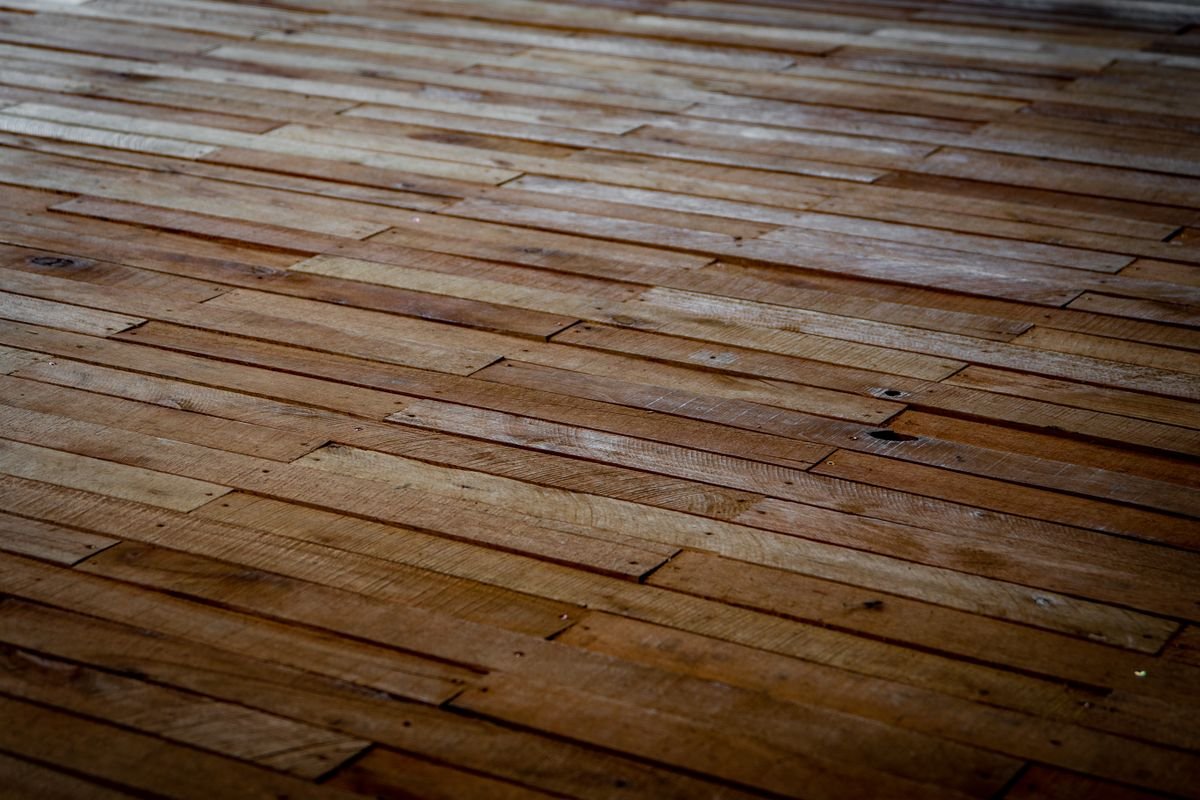 Rustic wooden floor with staggered planks showing natural texture