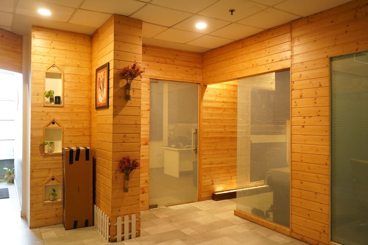 Office space with warm wooden wall panels and modern glass doors
