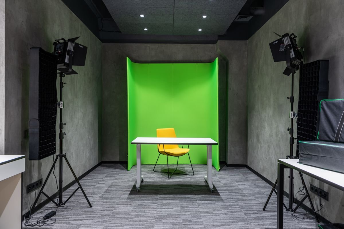 Studio room with a bold green accent wall and lighting equipment