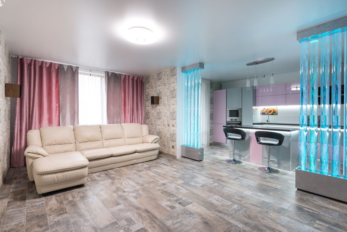 Living room with patterned wallpaper accent walls, pink curtains, and a corner sofa