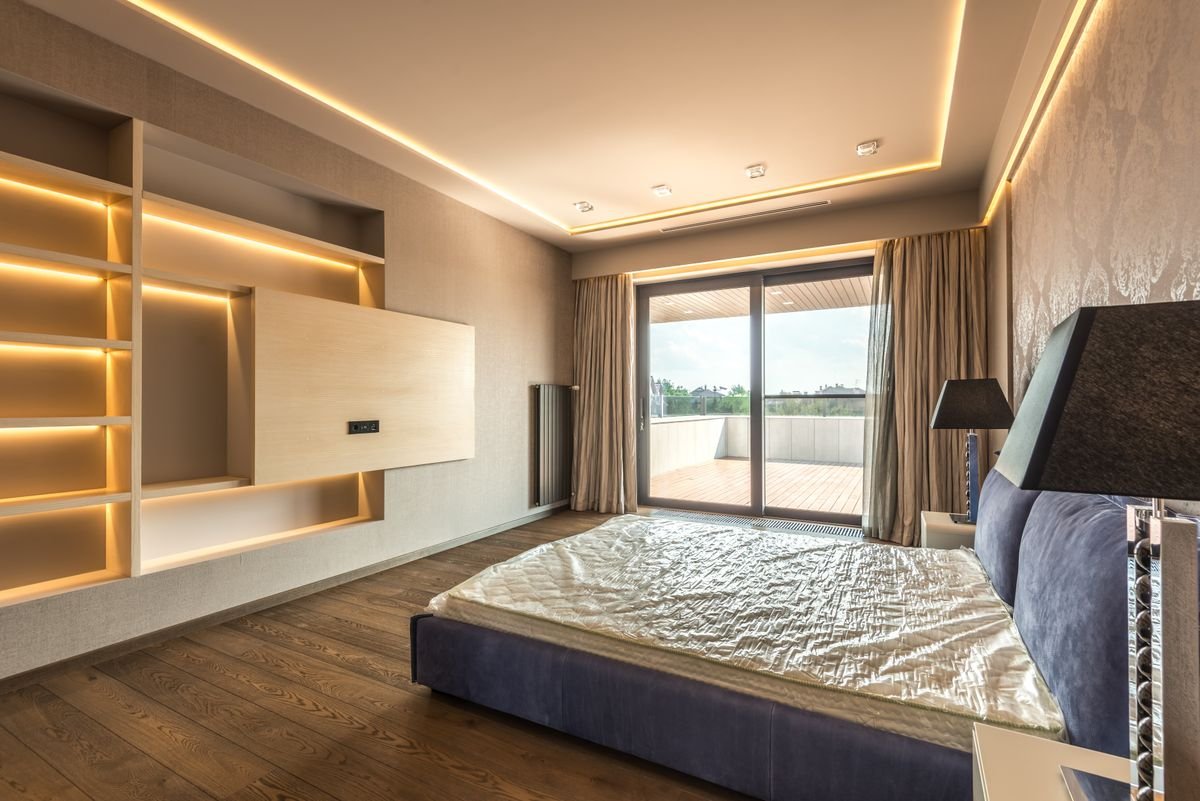 Bedroom with a wood-panelled feature wall and soft built-in lighting